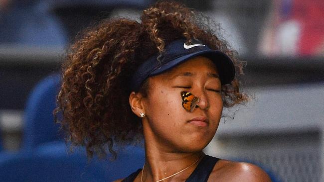 A butterfly lands on Naomi Osaka as she plays Ons Jabeur on day five of the Australian Open. Picture: Paul Crock