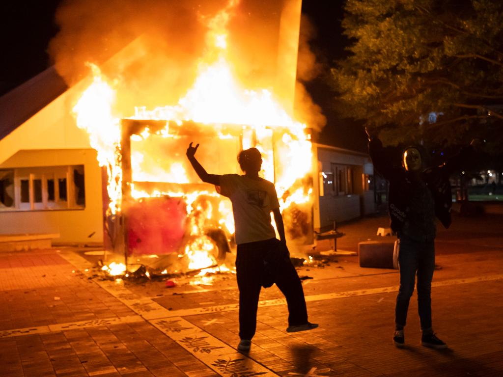 Activists celebrate as a building in Centennial Olympic Park burns in Atlanta. Picture: John Amis/AFP)