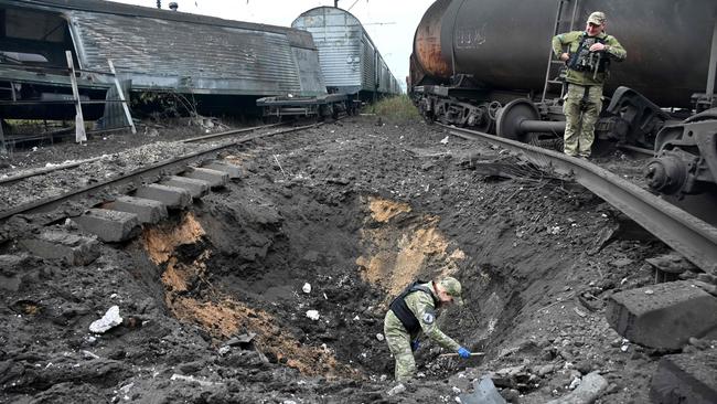 A forensic explosives expert examines a crater from a missile explosion at a freight railway station in Kharkiv on September 21, 2022, amid Russia's military invasion on Ukraine. Picture: AFP