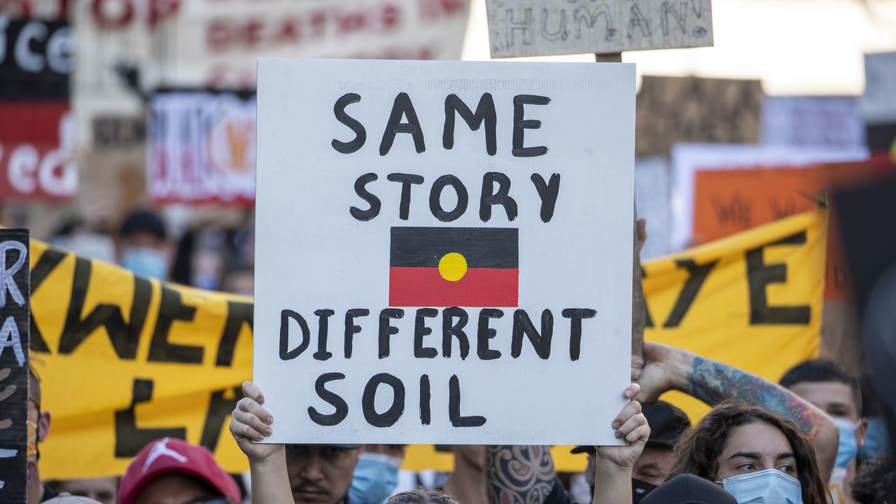 A sign reads “same story, different soil” at the protest in Brisbane. Picture: AAP/Glenn Hunt