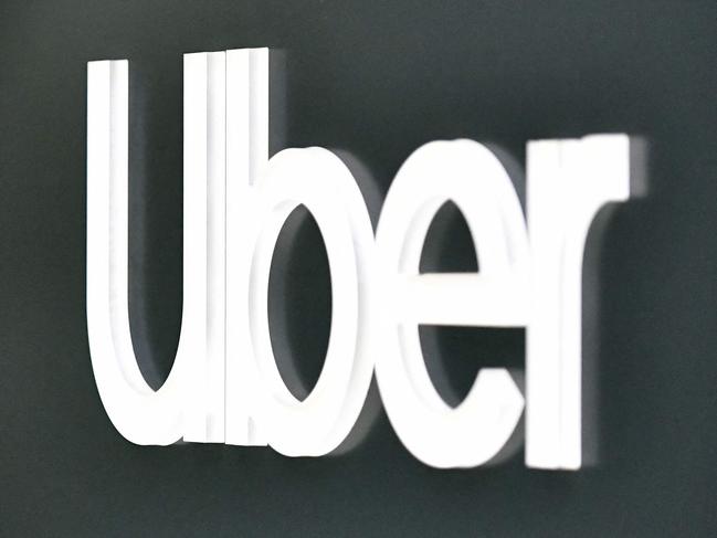 (FILES) In this file photo taken on May 08, 2019 an Uber logo is seen on a sign outside the company's headquarters location as people protest nearby in San Francisco, California. - Ride-hailing giant Uber has resumed its ride-sharing service in the United States, a top executive announced November 16, 2021, offering customers in Miami a feature that was stopped last year because of the Covid-19 pandemic (Photo by Josh Edelson / AFP)