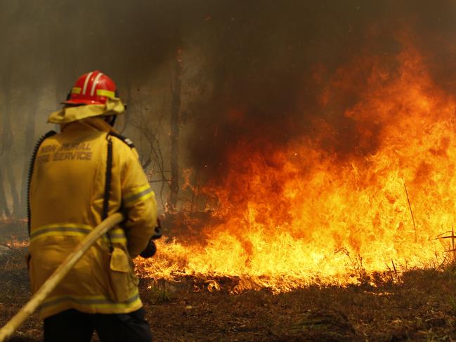 Firefighters working to contain a bushfire along Old Bar road in Old Bar, NSW. Picture: Darren Pateman