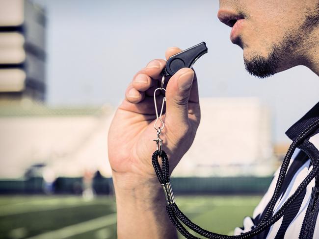 A football referee gets ready to blow his whistle. ipad generic