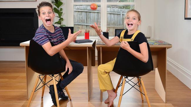 Jonathan Lawson’s children Ethan, 14, and Mia, 10, try out the cardboard desks. Picture: Nicki Connolly