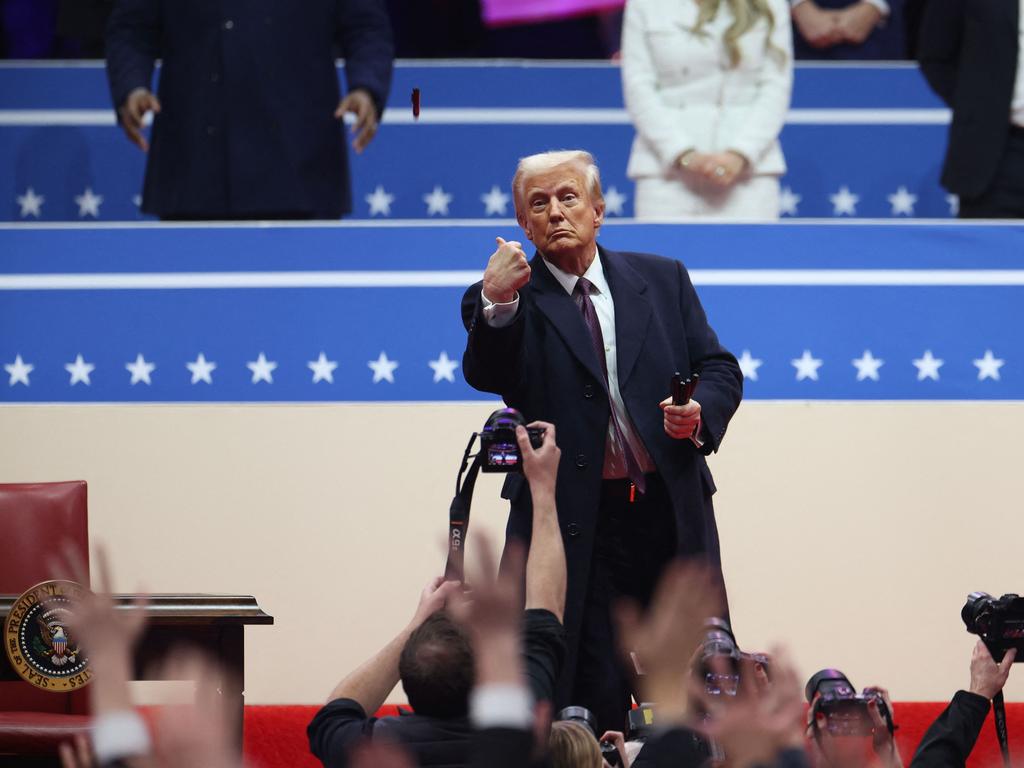 Donald Trump throws Sharpie pens into the crowd after signing executive orders. Picture: Getty Images via AFP