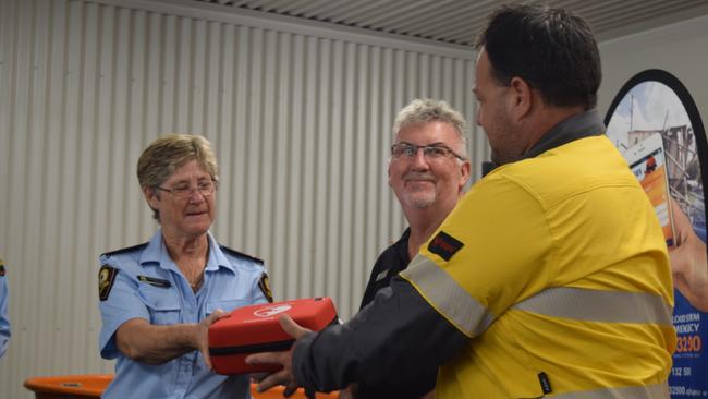 Christine Persello from Bowen SES and Whitsunday SES local controller Mark Connors accept a new defibrillator from Ergon Energy acting area manager Damian Pennisi. Photo: Elyse Wurm