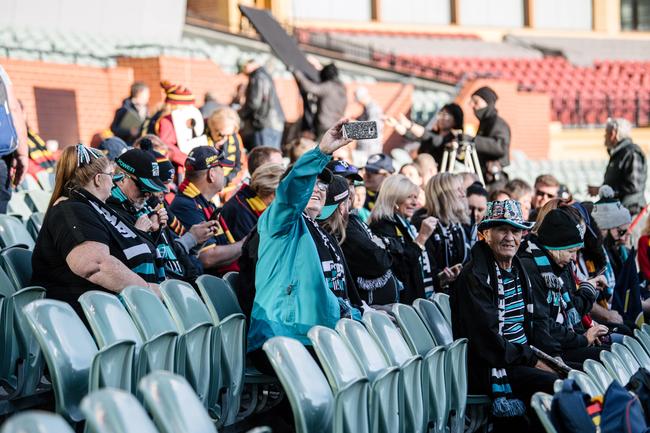 A Port Adelaide fan takes a selfie as she sits with other Port Adelaide and Crows fans on the southern side of Adelaide Oval. Picture: Morgan Sette/The Advertiser