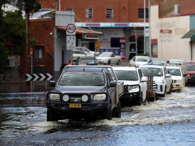 Cars drive through flood waters in Forbes, inundated by recent rains. Picture: Brendon Thorne
