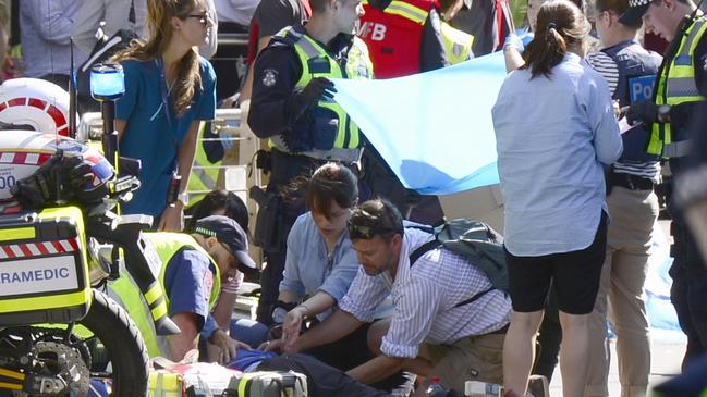 Paramedics attend to an injured pedestrian in Flinders Street. Picture: Cameron Tandy