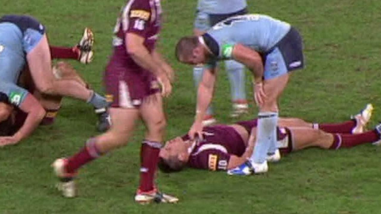 Justin Poore leans over Steve Price before lifting and then dropping the unconscious player in 2009.