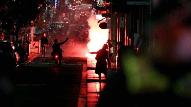 A flare is lit during an anti-lockdown protest in Melbourne’s CBD. Picture: AFP