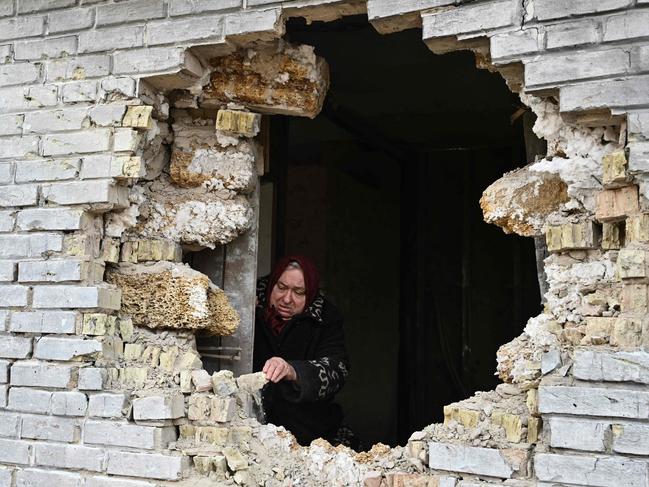 Local resident Nadiya, 65, shows a hole in a house after shelling in the village of Zalissya, northeast of Kyiv. Picture: Genya Savilov/AFP