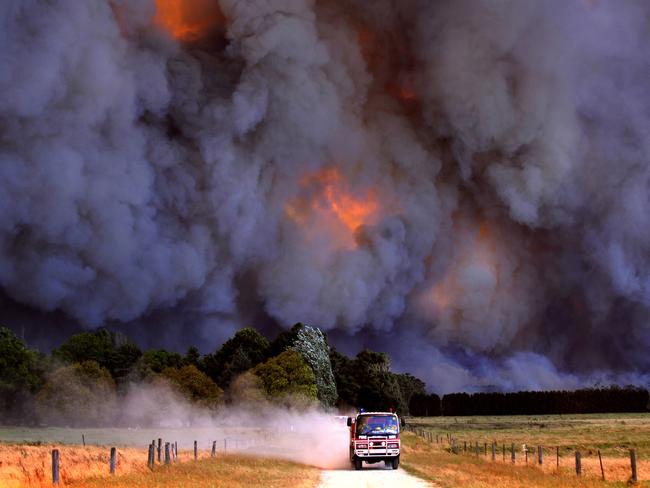 A CFA truck heads away from a giant blaze near Pakenham during the Victorian Black Saturday Bushfires. Picture: Alex Coppel