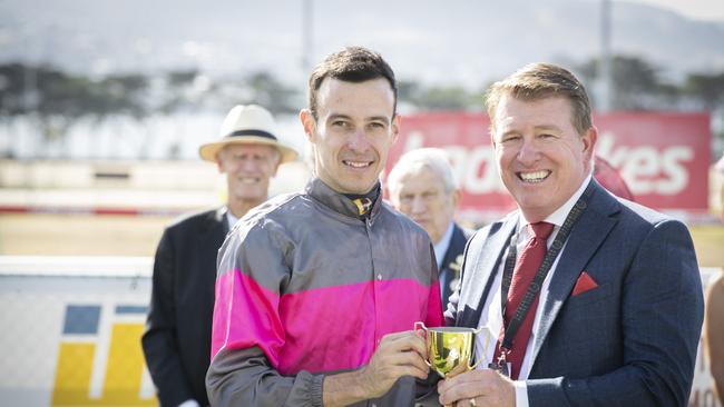 Aurora's Symphony ridden by Jordan Childs receives a trophy from Ladbrokes Karl deKroo after winning the Ladbrokes Hobart Cup at Elwick Racecourse. Picture: Chris Kidd