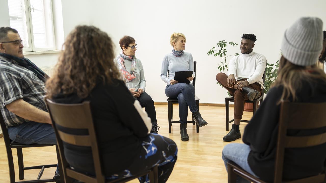 Group therapy support meeting talking about their mental health in a modern mental health facility