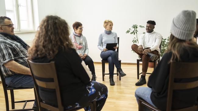 Group therapy support meeting talking about their mental health in a modern mental health facility