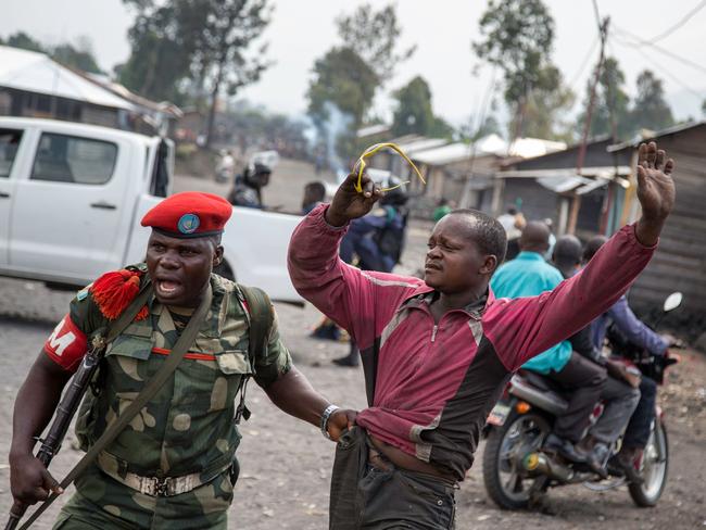A military police officer arrests a man in Majengo, in the Gomais area of the Democratic Republic of the Congo, after people attempted to block the road with rocks. Picture: AFP/Griff Tapper