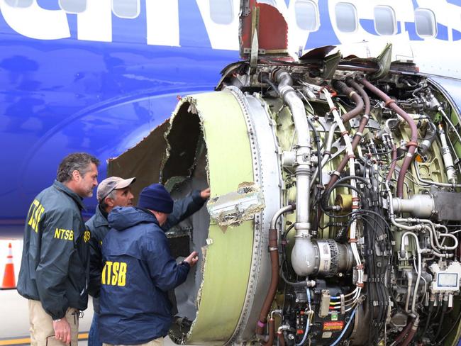 National Transportation Safety Board investigators examine damage to the engine of the Southwest Airlines plane. Picture: AP