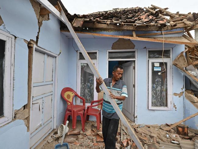 A man clears rubble from a house in Cugenang, Cianjur on November 23, 2022, following a 5.6-magnitude earthquake on November 21. - The death toll from an earthquake on Indonesia's main island of Java jumped to 268 on November 22, as rescuers searched for survivors in the rubble and relatives started to bury their loved ones. (Photo by ADEK BERRY / AFP)