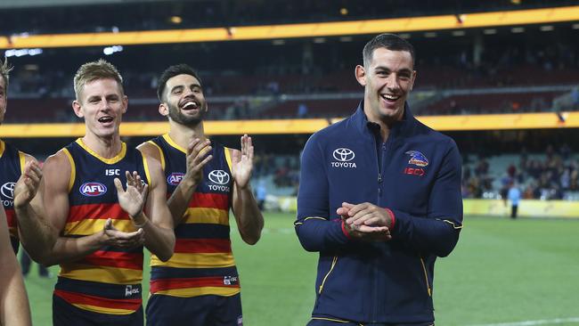 David McKay, Wayne Milera and Taylor Walker celebrate the win over the Gold Coast Suns at Adelaide Oval last night. Picture: SARAH REED