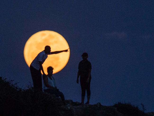 People watch the supermoon rising in Dar es Salaam, Tanzania on November 14, 2016. Picture: AFP PHOTO / DANIEL HAYDUK