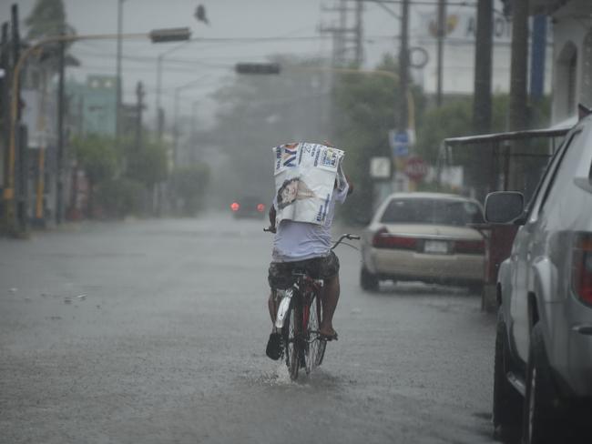 A resident rides his bike along a street as the Hurricane Willa arrives to Escuinapa, Sinaloa state, Mexico, on October 23, 2018. - Mexico braced Tuesday for the impact of Hurricane Willa as the Category 3 storm barreled toward its Pacific Coast with what forecasters warned would be potentially deadly force. (Photo by ALFREDO ESTRELLA / AFP)