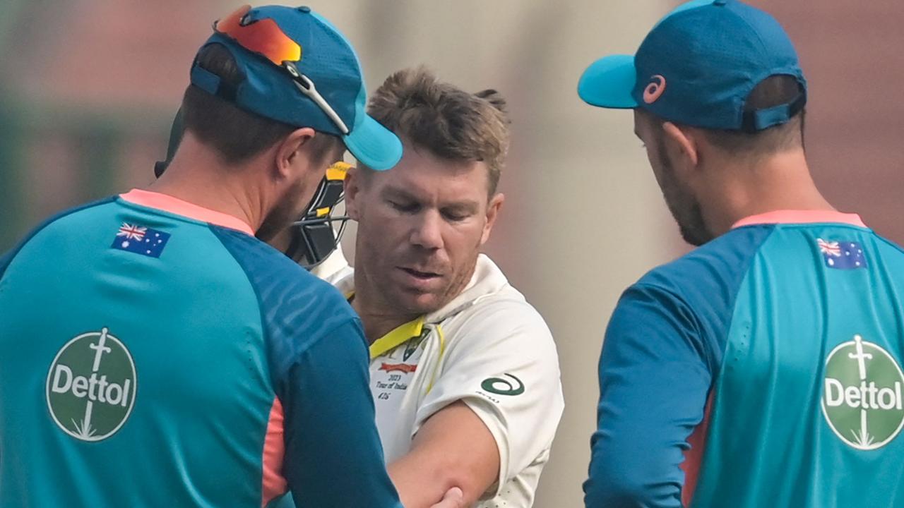 Australia's David Warner (C) gets medical aid during the first day of the second Test