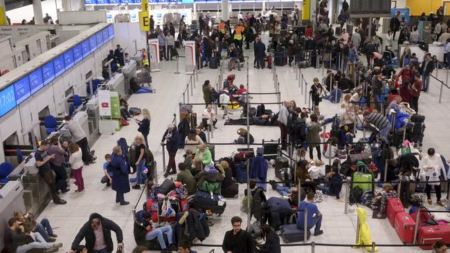 People wait in the departures area at Gatwick Airport, as the airport remains closed after drones were spotted over the runway. Picture: AP 