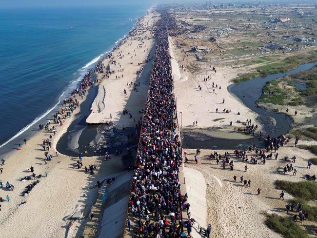 TOPSHOT - This aerial photo shows displaced Gazans walking toward Gaza City on January 27, 2025, after crossing the Netzarim corridor from the southern Gaza Strip. An unending stream of people marched up the coast of Gaza on January 27, carrying their belongings in plastic bags and repurposed flour sacks through the central city of Nuseirat after Israel reopened access to the territory's north. (Photo by AFP)