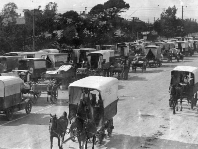 Sellers' horse-drawn buggies head down Grenfell St to pick up fruit and vegetables supplies to sell in the suburbs at the East End Market, 1929.