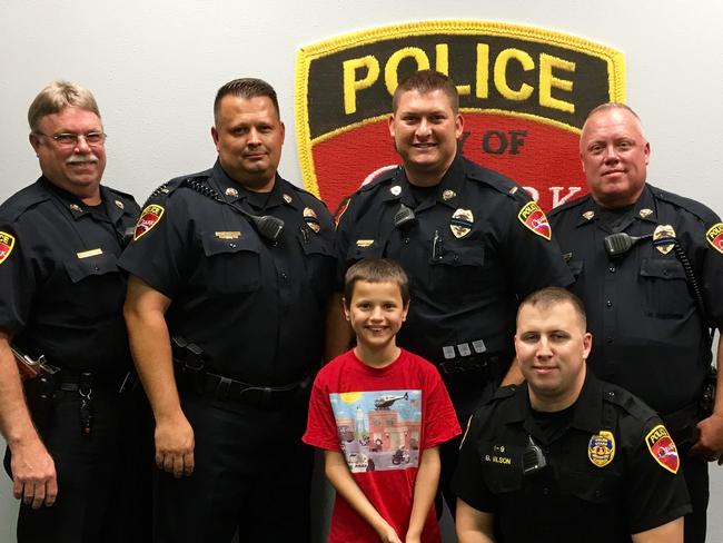 Caleb with his police friends in the US. Picture: Courtesy of Amy Neely