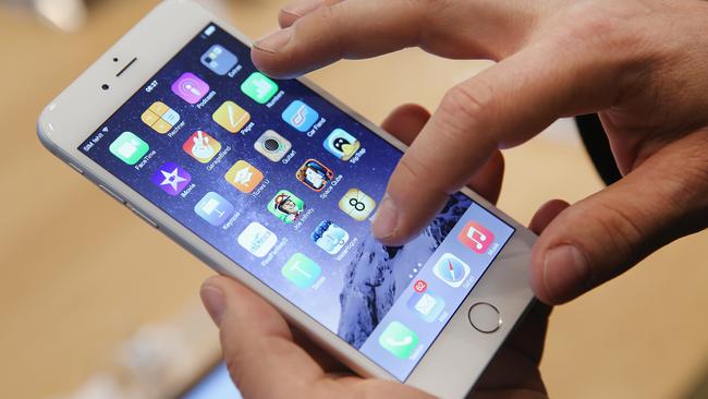 BERLIN, GERMANY - SEPTEMBER 19: A shopper ltries out the new Apple iPhone 6 at the Apple Store on the first day of sales of the new phone in Germany on September 19, 2014 in Berlin, Germany. Hundreds of people had waited in a line that went around the block through the night in order to be among the first people to buy the new smartphone, which comes in two versions: the Apple iPhone 6 and the somewhat larger Apple iPhone 6 Plus. (Photo by Sean Gallup/Getty Images)