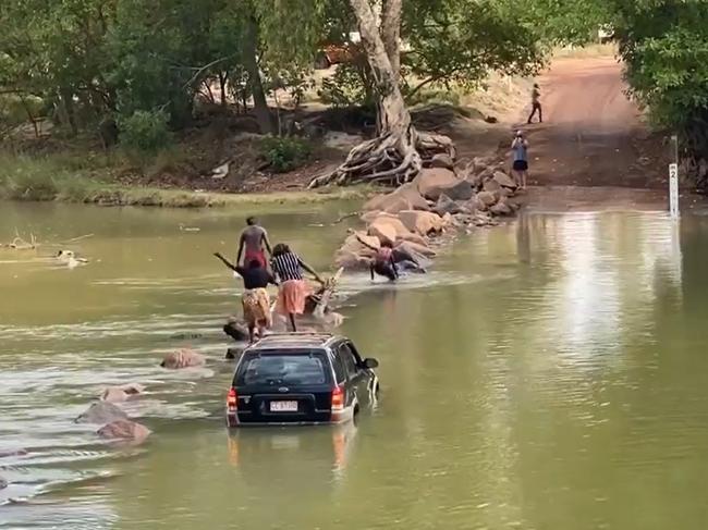 A bunch of crocheads who got bogged at Cahills Crossing in 2020, walking across the infamous body of water to get out, with one slipping in. Picture: Supplied