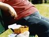 25/07/2011 NEWS: Mid-section of an overweight man sitting on a park bench with take-away food. Obese generic. Fat. Junk food. thinkstock Pic. Supplied