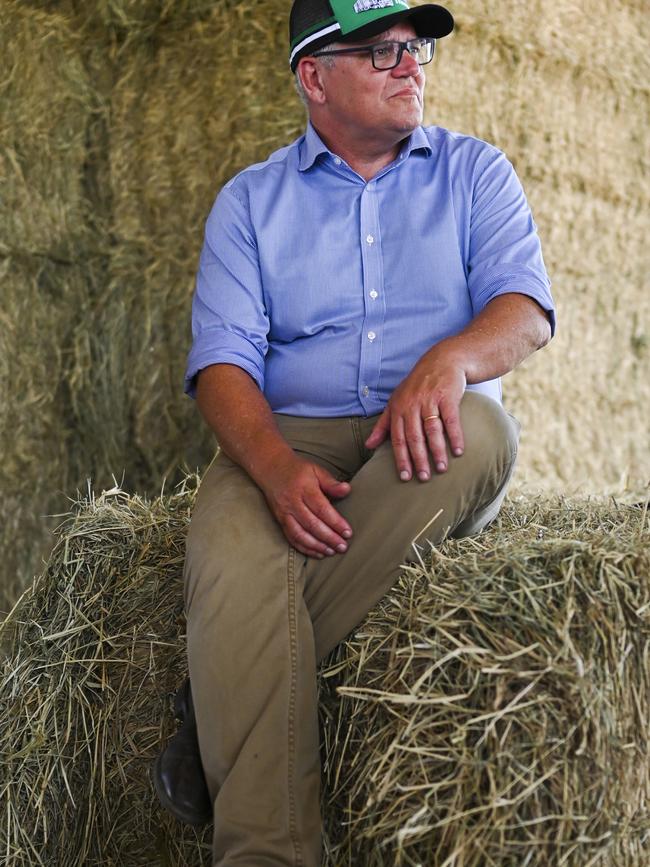 Prime Minister Scott Morrison speaks to local farmers during a visit to the saleyards in Winton, Queensland on Tuesday. Picture: AAP Image/Lukas Coch