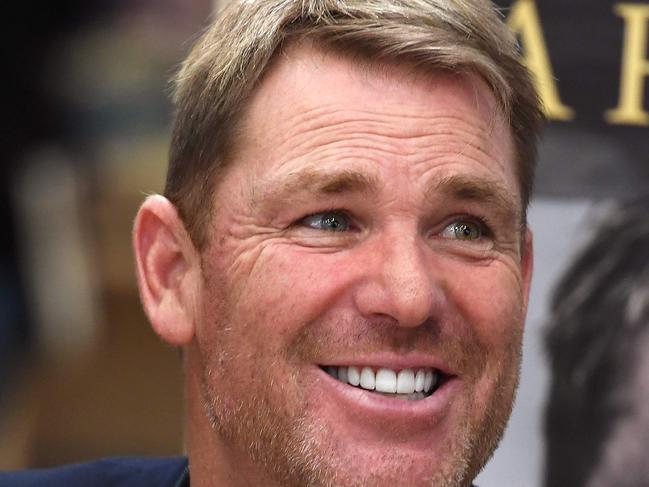Australian cricketing great Shane Warne chats with a customer during a book signing event for his new autobiography titled "No Spin", in Melbourne on October 19, 2018. - Warne, Test cricket's second-most prolific wicket-taker with 708 scalps, in his new book has endorsed one of the most controversial figures in cricketing history, while also renewing his decades-old feud with former captain Steve Waugh. (Photo by William WEST / AFP)