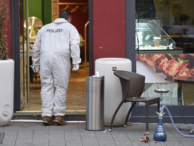 A forensic officer investigates the area in front of the fastfood restaurant in Reutlingen where a Syrian asylum-seeker killed a woman and injured two people with a machete. Picture: AFP