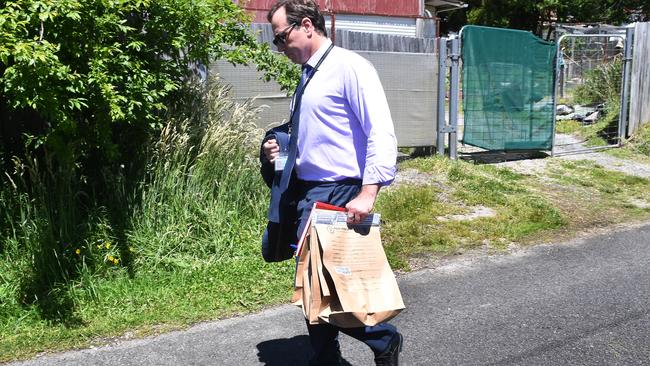 A New South Wales Police detective carries evidence bags as police begin excavation work at the house. Picture: AAP Image/Dean Lewins