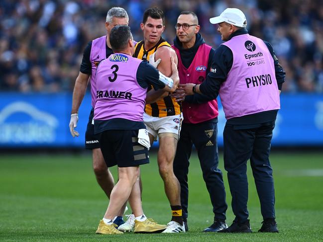 Jaeger O'Meara of the Hawks is attended to by trainers after a collision with Lachie Plowman.