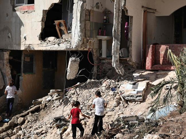 Survivors check the destruction in the aftermath of the raid in Qabatiyah. Picture: AFP