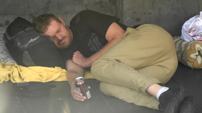 A man sleeps with a can of bourbon in his hand. Picture: Nicole Garmston