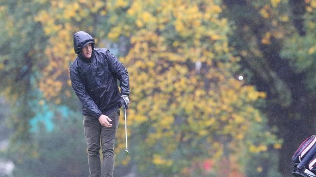 The rain didn’t deter golfers from heading onto the course. Picture: David Crosling