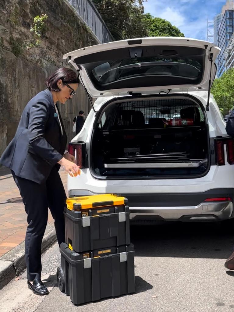 Police load boxes of evidence in to a car outside the luxury apartment of broadcaster Alan Jones who has been arrested. Picture: Supplied