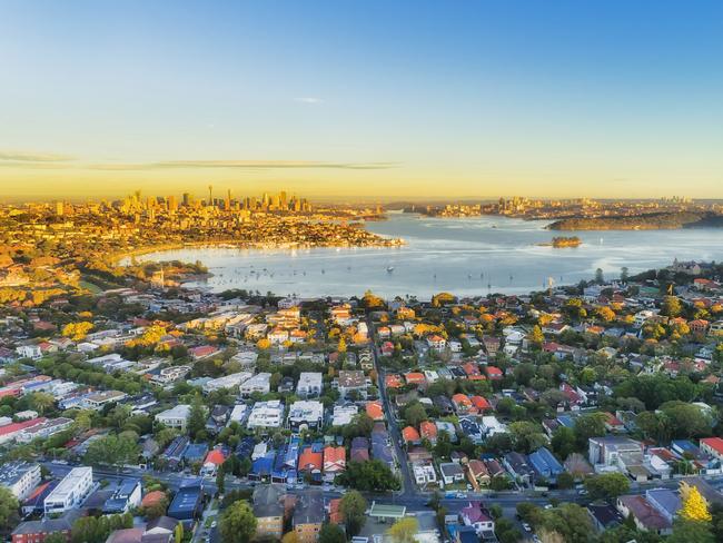 Wealthy Eastern suburbs of Sydney city around Harbour in aerial view with soft morning light and blue sky. Australian housing generic