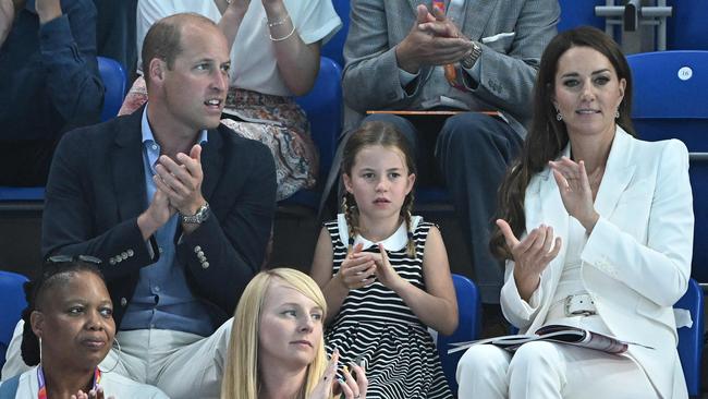 Britain's Prince William, Duke of Cambridge (L) and Britain's Catherine, Duchess of Cambridge (R) sit with their daughter Britain's Princess Charlotte of Cambridge (C) as they watch the men's 1500m freestyle heats swimming event at the Sandwell Aquatics Centre, on day five of the Commonwealth Games in Birmingham, central England, on August 2, 2022. (Photo by Oli SCARFF / AFP)