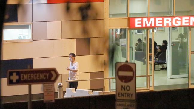 A man wearing a mask walks out of Westmead Hospital Emergency department in Western Sydney in January.