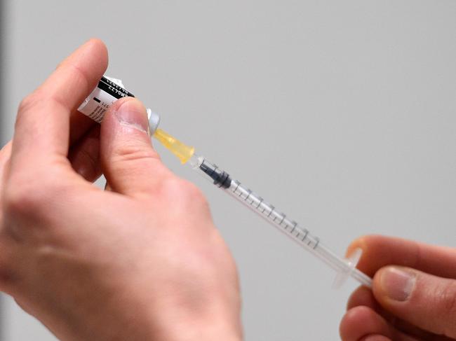 A health worker prepares a dose of the Pfizer-BioNTech Covid-19 vaccine at Jean Prouve Convention Centre on January 13, 2021 in Nancy, eastern France, during the first vaccination campaign for people over 75. (Photo by JEAN-CHRISTOPHE VERHAEGEN / AFP)