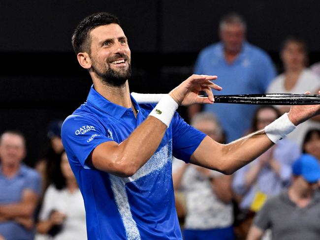 Novak Djokovic of Serbia pretends to play the violin after winning his men's singles match to secure a spot in the quarter-finals. Picture: AFP