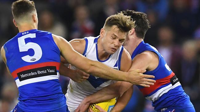 Shaun Higgins of the Kangaroos is tackled by Josh Dunkley and Bailey Williams of the Bulldogs on Saturday night. Picture: Getty Images