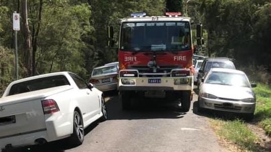 A North Warrandyte CFA fire truck just squeezes through cars parked on a road near the Yarra River on January 4. 